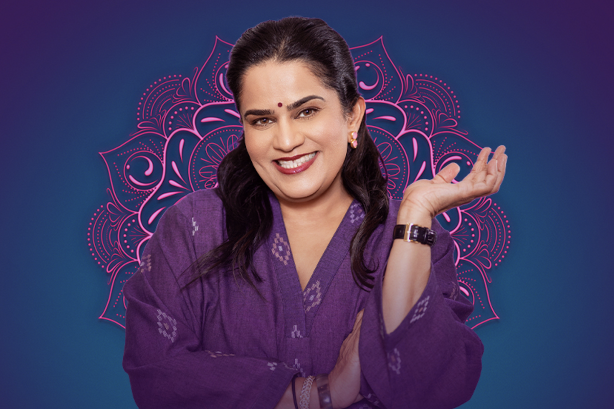 Indian-American comedian Zarna Garg smiling in a purple outfit against a pink mandala graphic background.